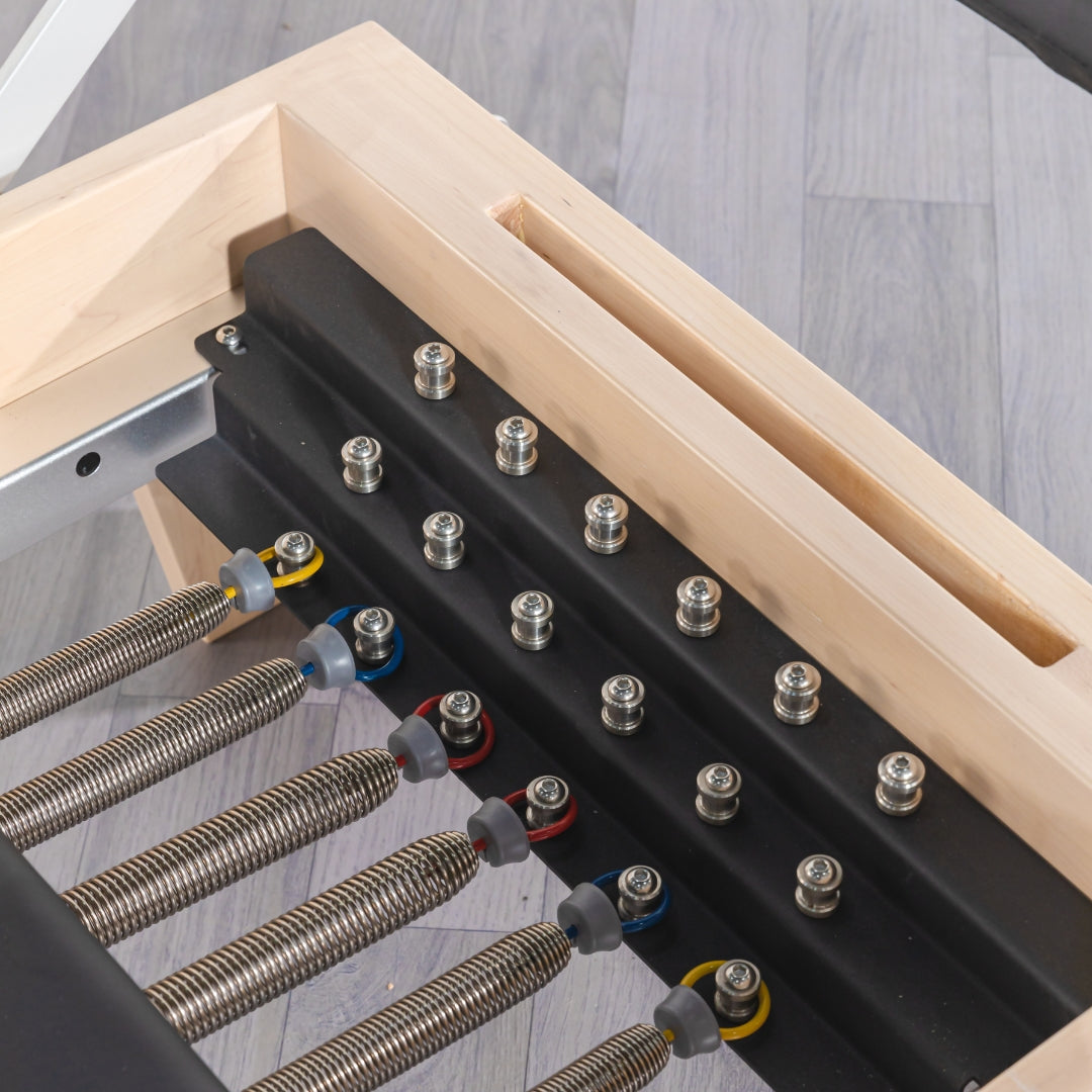 Reformer footbar and adjustable headrest features